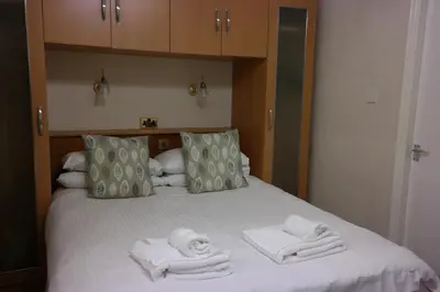 a bed with towels sitting on top of it at Arrandale Apartments in Douglas