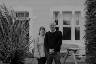 a man and a woman standing in front of a house at Cumbrian Lodge in Seascale
