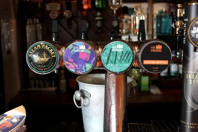 a bar with a bunch of different signs on a pole at The Steam Packet Inn in Isle of Whithorn