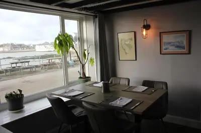 a dining room with a table and a large window at The Steam Packet Inn in Isle of Whithorn