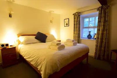 a bedroom with a bed with towels on it at Bottom Shop, Elterwater in Chapel Stile