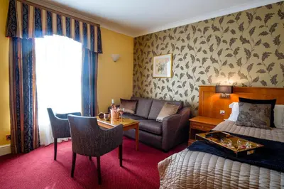 a hotel room with a bed and a couch and a table at The Gretna Chase Hotel in Gretna