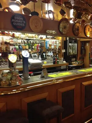 a bar in a pub with a counter and clocks at The Gretna Chase Hotel in Gretna