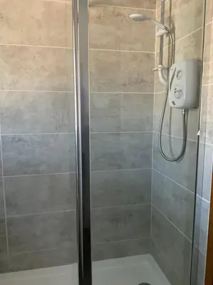 a bathroom with a shower with a glass door at Heron Lodge, edge of Mabie Forest Dumfries in Dumfries