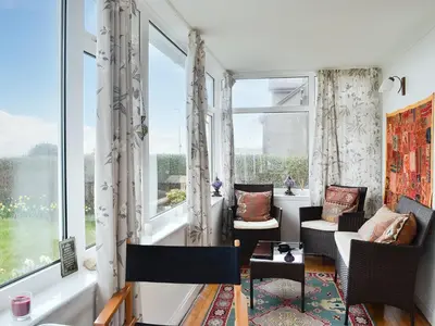 a living room with windows and chairs and a table at Craignair in Port William