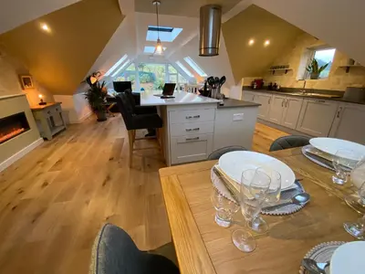 a kitchen with a table with plates and glasses on it at Latrigg View in Keswick