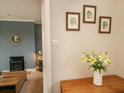 a living room with a vase of flowers on a table at The Crook in Penrith