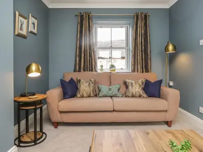 a living room with a couch and a window at The Crook in Penrith