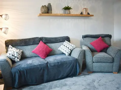 a living room with a couch and two chairs at Eskin Den in Keswick