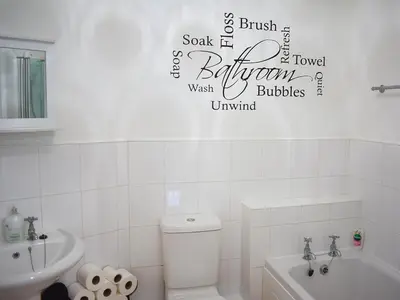 a white bathroom with a toilet and a sink at Eskin Den in Keswick