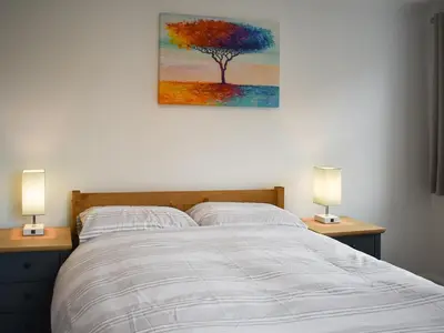 a bedroom with a bed with a painting on the wall at Eskin Den in Keswick