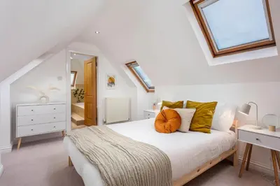 a bedroom with a white bed with orange pillows on it at Sunset View - Donnini Apartments in Ayr
