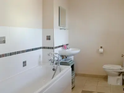 a bathroom with a tub and a sink and a toilet at Laird House in Lochmaben