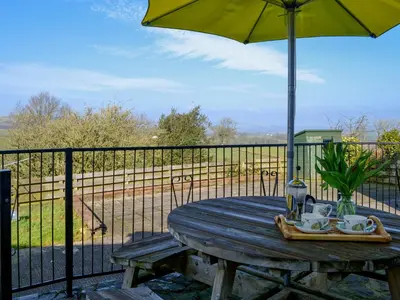 a picnic table with an umbrella on a fence at Laird House in Lochmaben