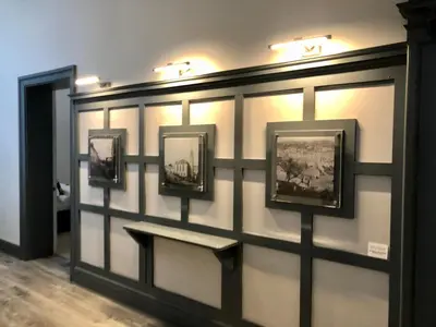 a wall with four pictures on it with a bench at East Church House, Unique 9 bedroom Church, Historic Market Town. in Strathaven