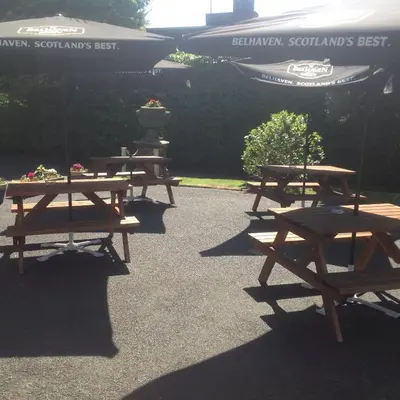 a group of picnic tables sitting in a parking lot at Edenbank Hotel in Dumfries