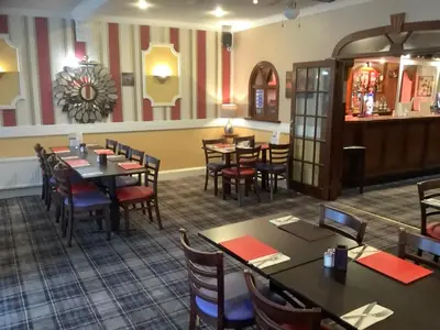 a dining room with tables and chairs in a restaurant at Edenbank Hotel in Dumfries