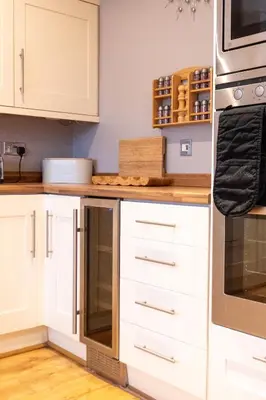a kitchen with white cabinets and a counter at Four Oaks Cottage in Rockcliffe