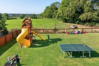 a playground with a slide and a table tennis at Four Oaks Cottage in Rockcliffe
