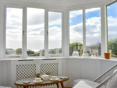 a room with windows and a table and chairs at Loanmhor in Kilmory