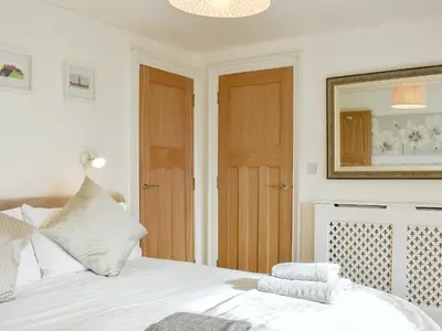 a bedroom with a white bed and a mirror at Loanmhor in Kilmory