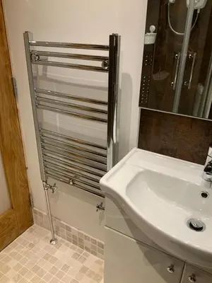 a bathroom with a white sink and a shower at Dove Cottage (Annex) in Workington
