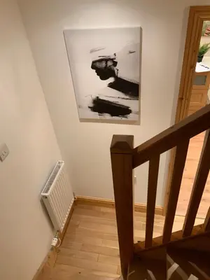a staircase with a picture on the wall and a radiator at Dove Cottage (Annex) in Workington