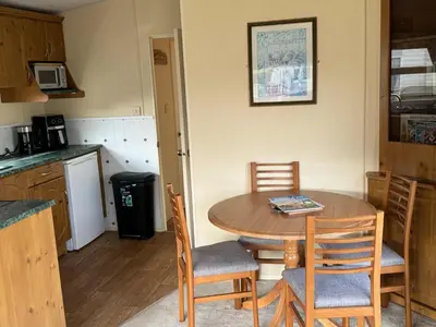 a kitchen with a table and chairs in a room at Happydays Caravan 1 Newton Stewart in Bailliewhir