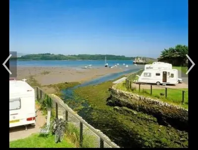 a group of vehicles parked next to a body of water at Happydays Caravan 1 Newton Stewart in Bailliewhir