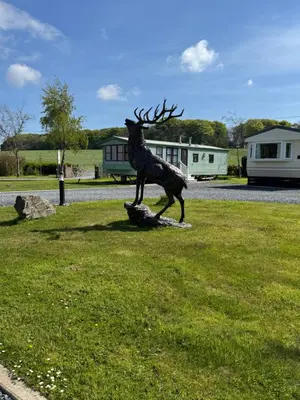a statue of a reindeer standing on a log at Happydays Caravan 1 Newton Stewart in Bailliewhir