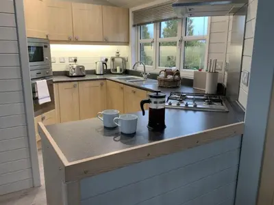 a kitchen with a counter with two mugs on it at Holly Blue - Cosy wooden lodge Kippford in Dalbeattie