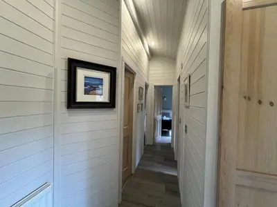 a hallway of a home with white walls and wood floors at Holly Blue - Cosy wooden lodge Kippford in Dalbeattie