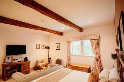 a bedroom with a bed and a tv and a window at The Fleece at Ruleholme in Carlisle