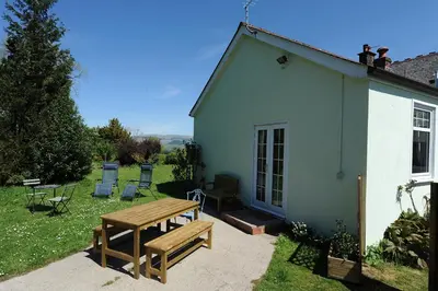 a picnic table and chairs outside of a house at The Green House at Tathhill in Beattock