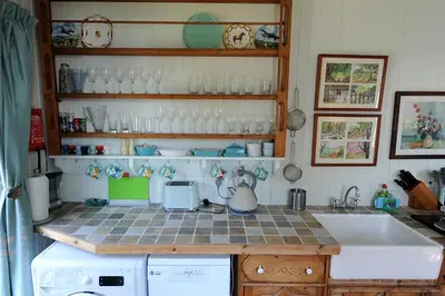 a kitchen with a sink and a counter with glasses at The Green House at Tathhill in Beattock