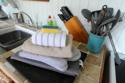 a pile of towels sitting on a counter next to a sink at The Green House at Tathhill in Beattock
