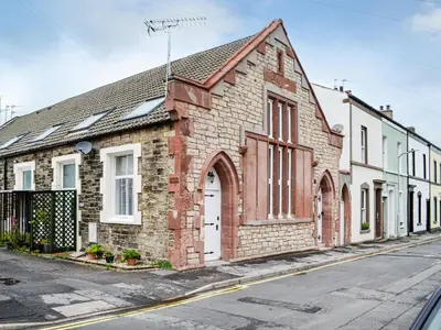 an old brick building on the side of a street at Chapel Mouse Cottage in Cockermouth