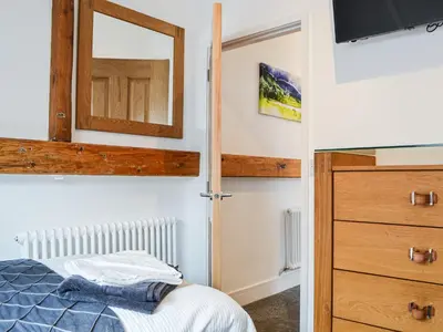 a bedroom with a bed and a mirror at Chapel Mouse Cottage in Cockermouth