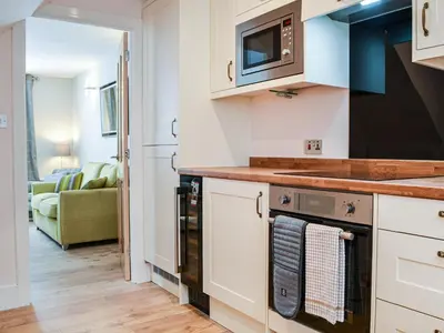 a kitchen with a stove and a microwave at Chapel Mouse Cottage in Cockermouth