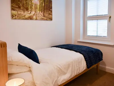 a bedroom with a bed with a picture on the wall at Walkers Retreat in Keswick