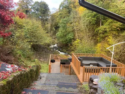 a wooden staircase leading down to a river with trees at Kirkwirral Bed & Breakfast in Dumfries