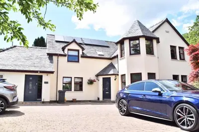 a blue car parked in front of a house at Kirkwirral Bed & Breakfast in Dumfries