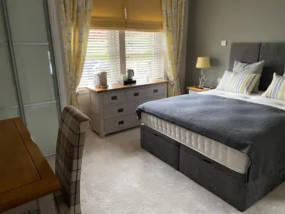 a bedroom with a large bed and a window at Kirkwirral Bed & Breakfast in Dumfries