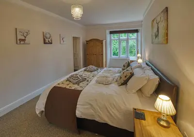 a bedroom with a large bed and a window at Tallentire Hall in Cockermouth