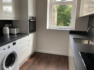 a kitchen with a washing machine and a window at Tallentire Hall in Cockermouth