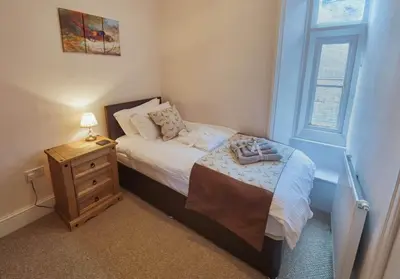 a small bedroom with a bed and a night stand at Tallentire Hall in Cockermouth