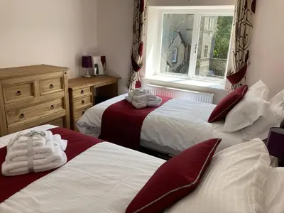 a bedroom with two beds with red and white sheets at Tallentire Hall in Cockermouth
