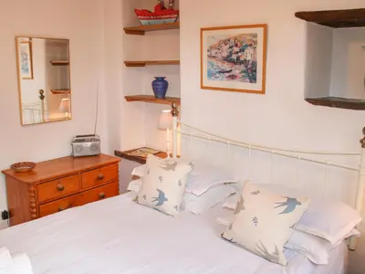 a bedroom with a bed with white sheets and pillows at Plosh House in Keswick