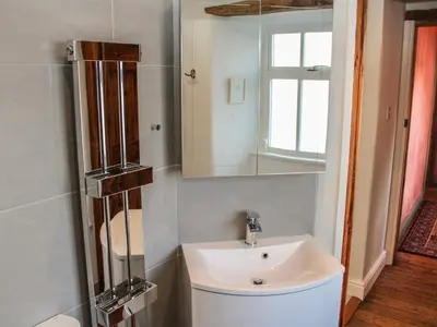 a bathroom with a sink and a mirror at Plosh House in Keswick