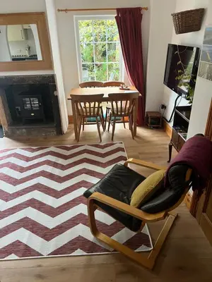 a living room with a table and a rocking chair at Robinsons Cottage, central and quiet in Cockermouth
